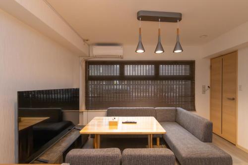 a living room with a couch and a table at Ocean Nipponbashi Higashi in Osaka