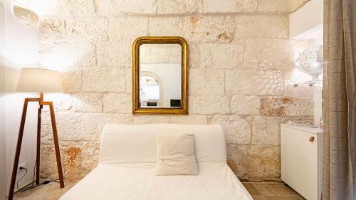 a bedroom with a white bed and a mirror at White Rose by Rentbeat in Ostuni