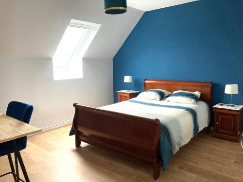 a bedroom with a bed and a blue wall at Maison non fumeur - jardin 5 personnes proche des plages finistériennes in Guipavas