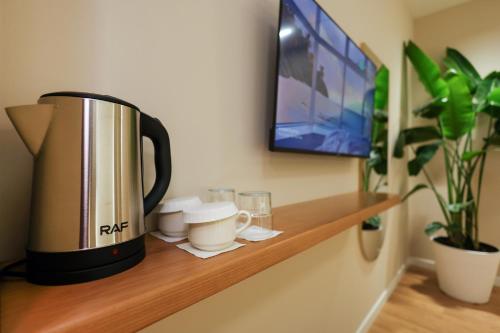 a coffee maker on a wooden shelf with a tv at Beratinus1 in Berat