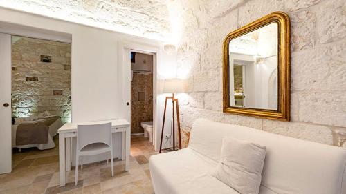 a living room with a white couch and a mirror at White Rose by Rentbeat in Ostuni