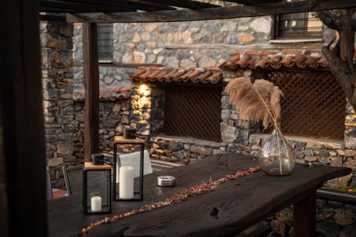 a wooden table with a vase and candles on it at 4 Seasons Premium Chalet & Massage Treatments in Palaios Agios Athanasios