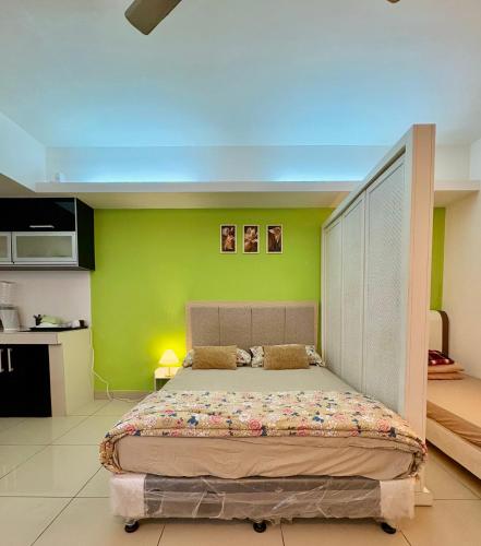 a bedroom with a large bed with a green wall at Private Studio Viana Court Service Apartment 3 with private parking in Kota Bharu