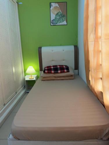 a bed in a room with a green wall at Private Studio Viana Court Service Apartment 3 with private parking in Kota Bharu