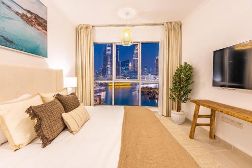 a living room with a bed and a large window at the Byron Bay condo in Dubai