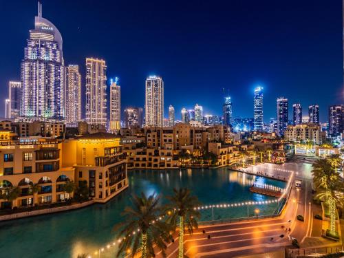 a city skyline at night with a body of water at the Byron Bay condo in Dubai