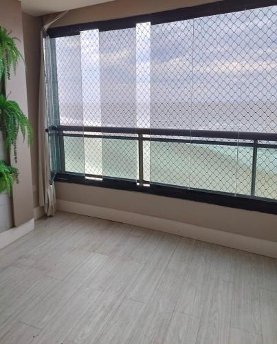an empty room with a large window in a building at Apartamento Vista Mar in São Luís
