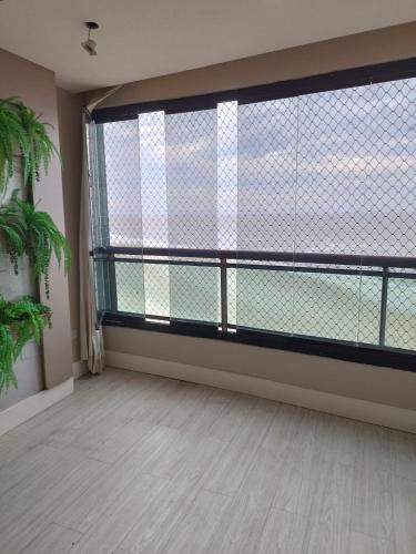 an empty room with a large window and a floor at Apartamento Vista Mar in São Luís