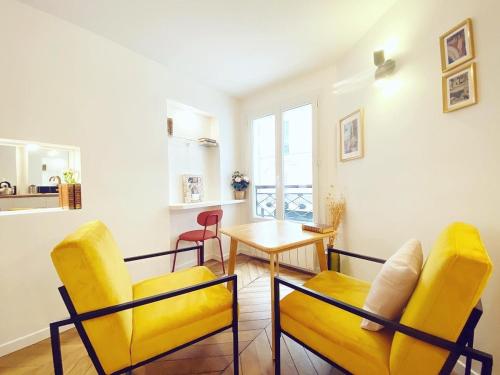 un salon avec des chaises jaunes et une table dans l'établissement Superbe appartement a Paris - FLAT-GUEST, à Paris