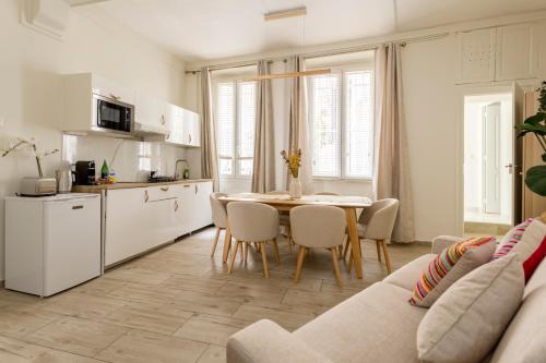 une cuisine et une salle à manger avec une table et des chaises dans l'établissement Reva Suites, à Paris