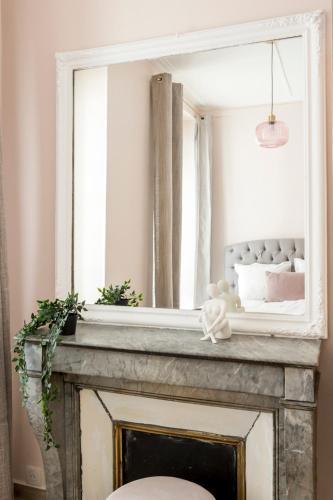 Elle comprend une cheminée avec un miroir. dans l'établissement Reva Suites, à Paris