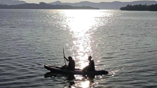two people are sitting on a boat in the water at Bankruchaem Homestay Kohpu in Ban Klang