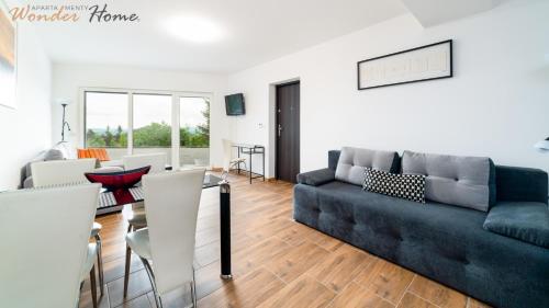a living room with a couch and a table at Wonder Home- blisko szlaków, z trasami i pięknym widokiem in Karpacz