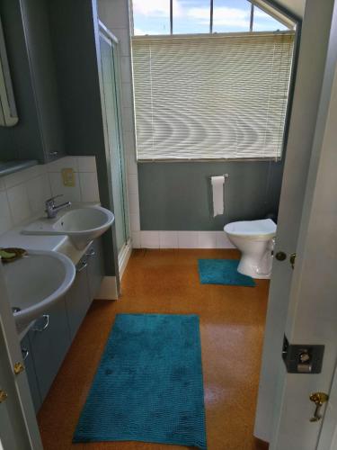 a bathroom with two sinks and a toilet and a window at Susan's Holiday House in Hamilton