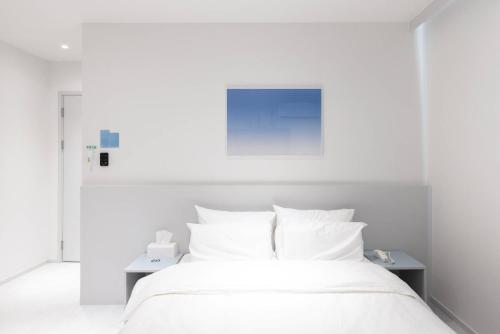 a white bed with white sheets and pillows at 은행 아늑에어 대전역점 Aank Air Hotel Daejeon Station in Daejeon