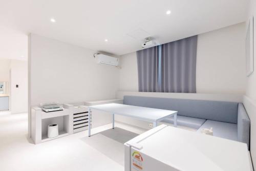 a white room with a desk and a table at 은행 아늑에어 대전역점 Aank Air Hotel Daejeon Station in Daejeon