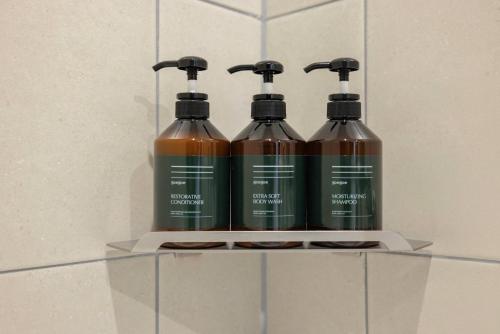 a group of four shampoo bottles sitting on a shelf at 은행 아늑에어 대전역점 Aank Air Hotel Daejeon Station in Daejeon