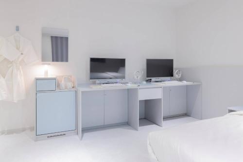 a white desk with a monitor and a computer on it at 은행 아늑에어 대전역점 Aank Air Hotel Daejeon Station in Daejeon