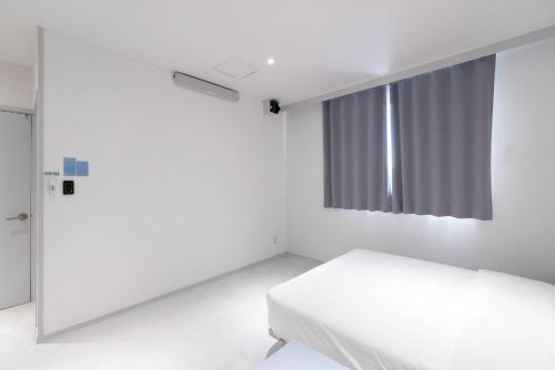 a white room with a bed and a window at 은행 아늑에어 대전역점 Aank Air Hotel Daejeon Station in Daejeon