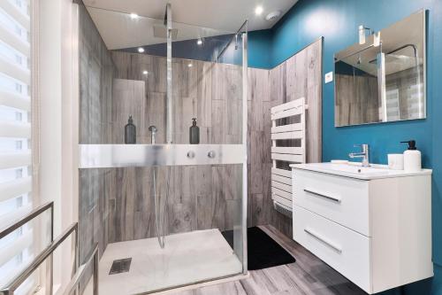 une salle de bain avec une douche avec un lavabo et un miroir dans l'établissement Le Jacquart Centre-ville Spacieux Confort, à Reims