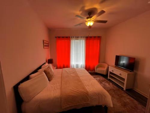 a bedroom with a bed with a ceiling fan and a television at Peaceful Vacation Spot with Modern Touches and Amazing Ambiance in Leander