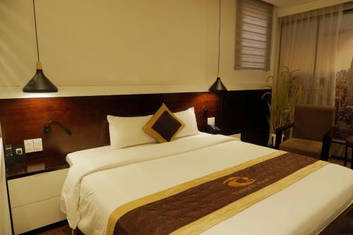 a bedroom with a large bed with a wooden headboard at Tuong Vi 2 in Hai Phong