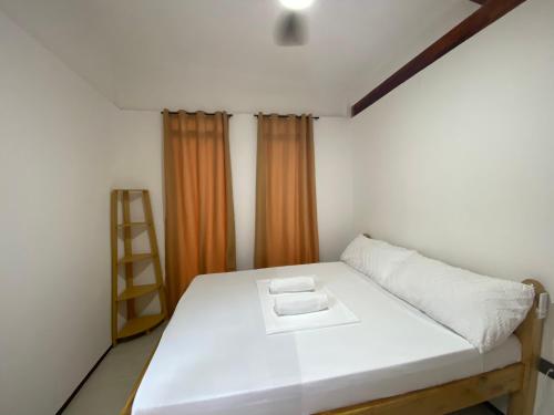 a bedroom with a white bed and a ladder at MHARI Guest Rooms in San Juan