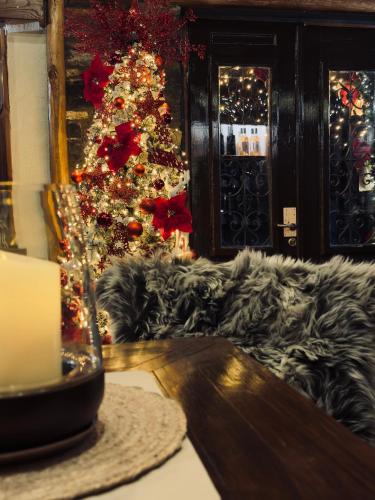 a christmas tree in a living room with a table at 4 Seasons Premium Chalet & Massage Treatments in Palaios Agios Athanasios