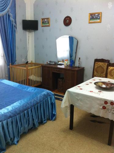 a bedroom with a bed and a table and a mirror at Hasanovs Villa in Baku