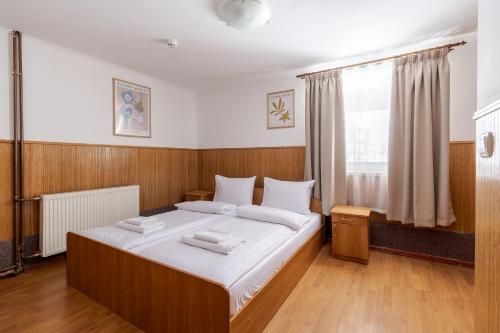 a bedroom with a large bed with white sheets at Robert Hotel in Dragobrat