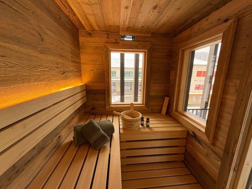 an empty sauna with a window in a wooden cabin at Aloha Suite - Schladming Dachstein in Haus im Ennstal