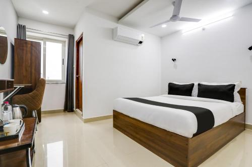 a bedroom with a bed and a desk in a room at Super Collection O De Alphabet Hotel in Hyderabad