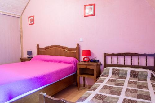 - 2 lits dans une chambre aux murs roses dans l'établissement Le castel, à Laval-du-Tarn