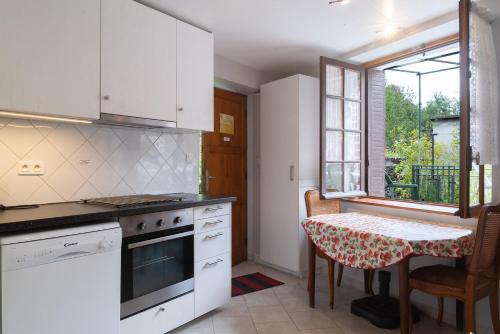 Il comprend une cuisine équipée d'une cuisinière et d'une table. dans l'établissement Clevacances 2 cles 4 personnes a pont ravagers, à Sainte-Croix-Vallée-Française