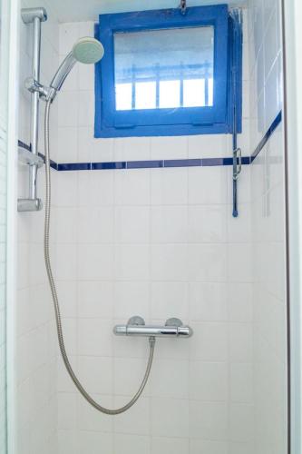La salle de bains est pourvue d'une douche et d'une fenêtre bleue. dans l'établissement Clevacances 2 cles 4 personnes a pont ravagers, à Sainte-Croix-Vallée-Française