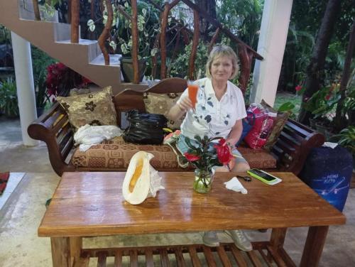 a woman sitting on a couch with a coffee table at Turtle Paradise in Tangalle