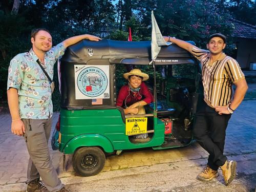 two men are standing next to a small vehicle at Turtle Paradise in Tangalle
