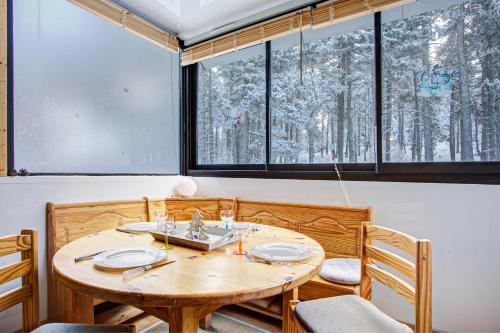 - une salle à manger avec une table en bois et 2 fenêtres dans l'établissement Les Lupins - Station de ski à pied, à Eyne
