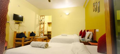 a hotel room with two beds and a living room at JMT Eco-Binsar by StayApart in Panuānaula