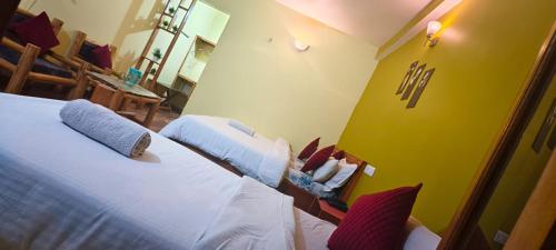 a bedroom with two beds and a yellow wall at JMT Eco-Binsar by StayApart in Panuānaula