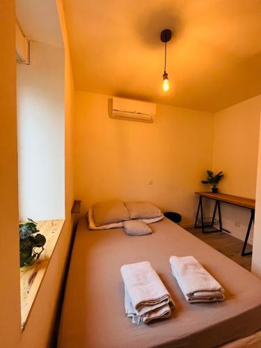 - un lit dans une chambre avec 2 serviettes dans l'établissement Jolis logements brivistes 3, à Brive-la-Gaillarde