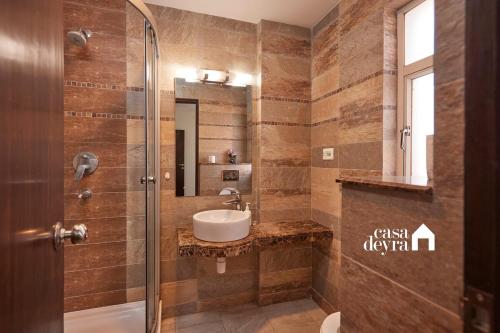 a bathroom with a sink and a glass shower at Elegant Edge 3BHK Apartment in Pātan