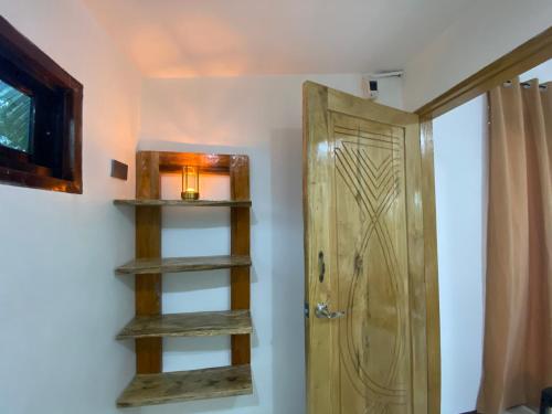 a room with a wooden door and a shelf at MHARI Guest Rooms in San Juan