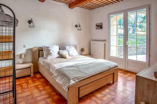 une chambre avec un lit et une grande fenêtre dans l'établissement Villa Cheval Blanc by Villa Plus, à Cheval-Blanc