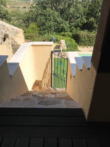 un escalier avec une porte dans un bâtiment avec piscine dans l'établissement La Cloche Qui Rit kamers, à Balazuc