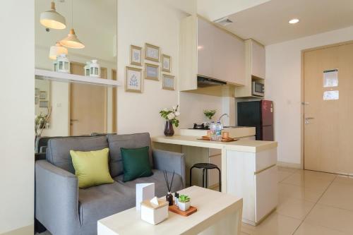 a living room with a couch and a kitchen at Calma 1BR I at TreePark Apartment in Dadap