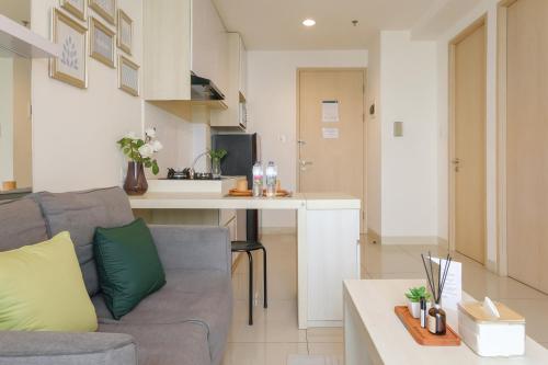 a living room with a couch and a kitchen at Calma 1BR I at TreePark Apartment in Dadap