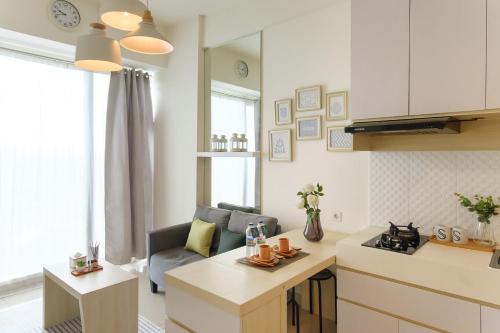 a kitchen and living room with a couch and a table at Calma 1BR I at TreePark Apartment in Dadap