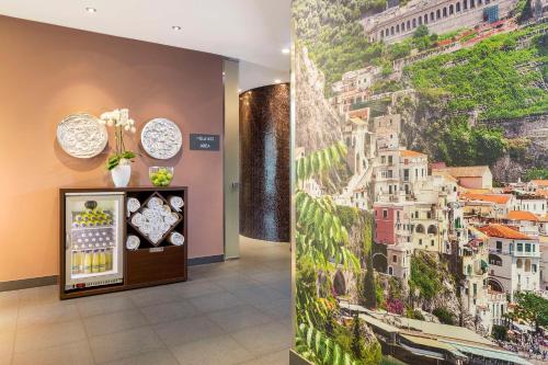 a hallway with a wall mural of a city at NH Collection Dresden Altmarkt in Dresden
