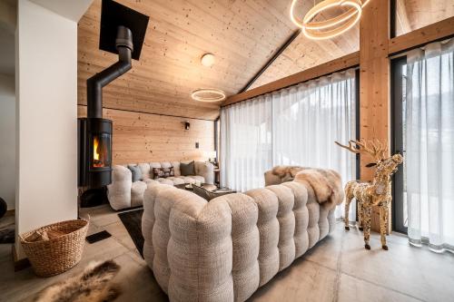 - un salon avec un grand canapé et une cheminée dans l'établissement Chalet Marguerite, Morzine - by EMERALD STAY, à Montriond